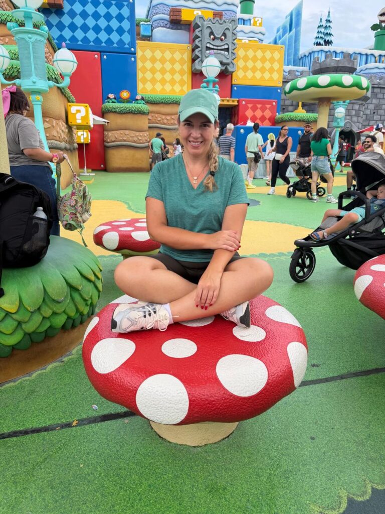 Visitante sentada em um cogumelo gigante no Super Nintendo World do Epic Universe