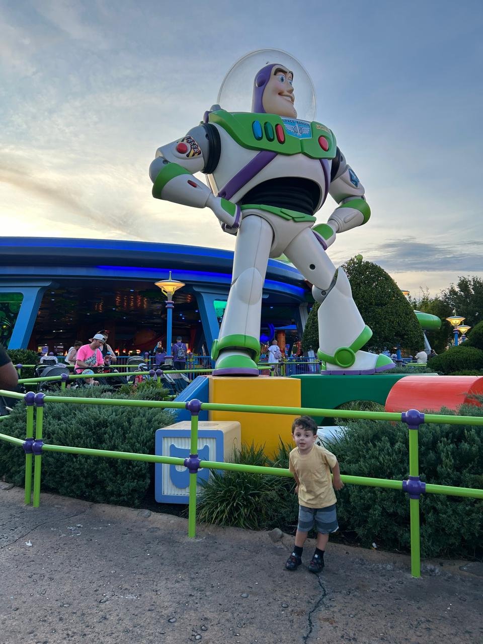 Criança ao lado da estátua gigante do Buzz Lightyear em Toy Story Land, no Hollywood Studios da Disney