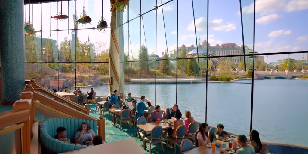 Restaurante com janelas amplas e vista para o lago no Celestial Park do Epic Universe